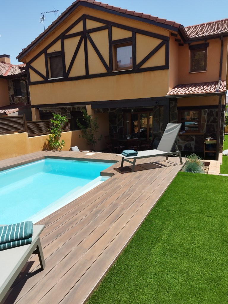 Jardín trasero con piscina, ducha y bar