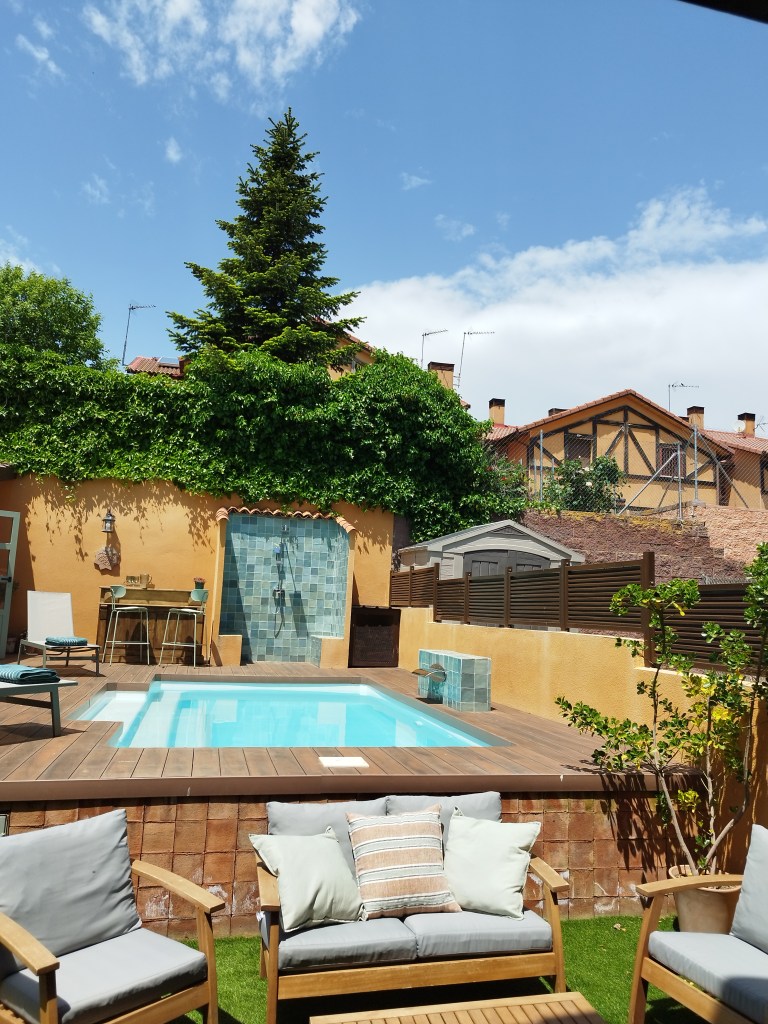 Jardín trasero con piscina, ducha y bar